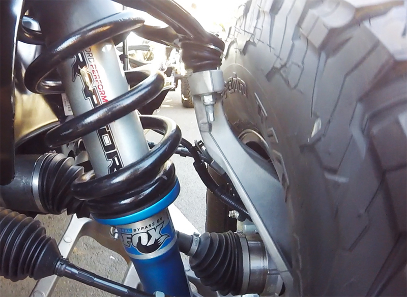 The coilover shock looks big as a sewer pipe. You can also see the Raptor’s robust control arms, axles and tie rod ends from here (Photo Credit: Andrew Collins)